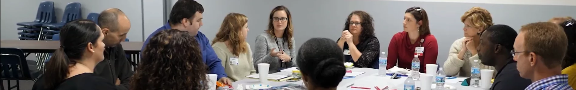 Students in class talking around a table